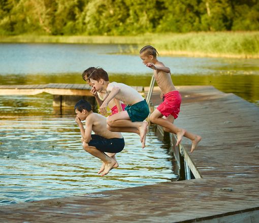 Bērni lec ezerā
