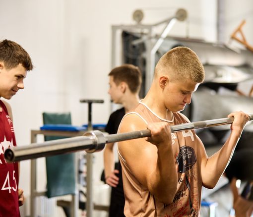 Bērns ceļ svarus svaru zālē